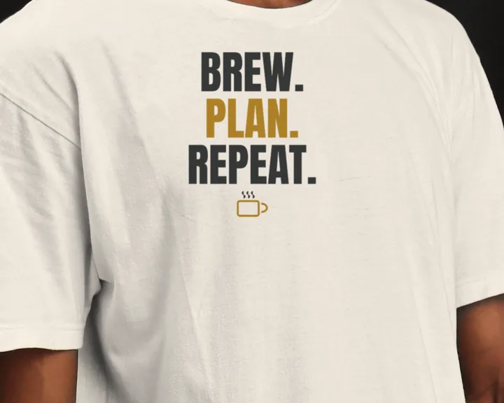 Man wearing a white "Brew. Plan. Repeat." tee in a dark studio