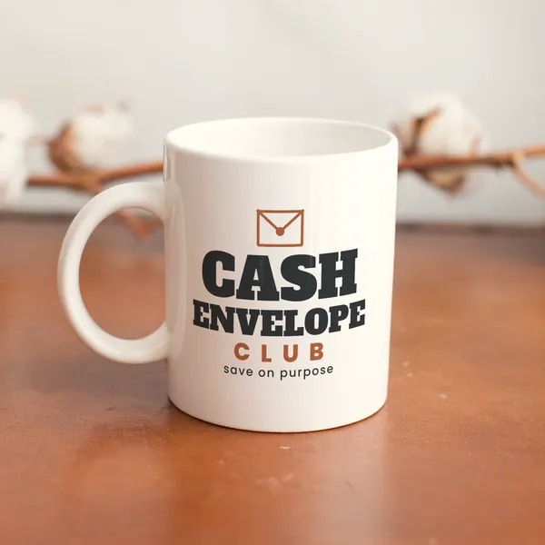 White 11 oz ceramic mug printed with "Cash Envelope Club" on a wooden table