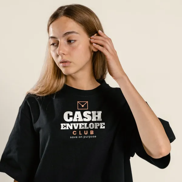 Model wearing a black "Cash Envelope Club" tee with the light-ink version of the design