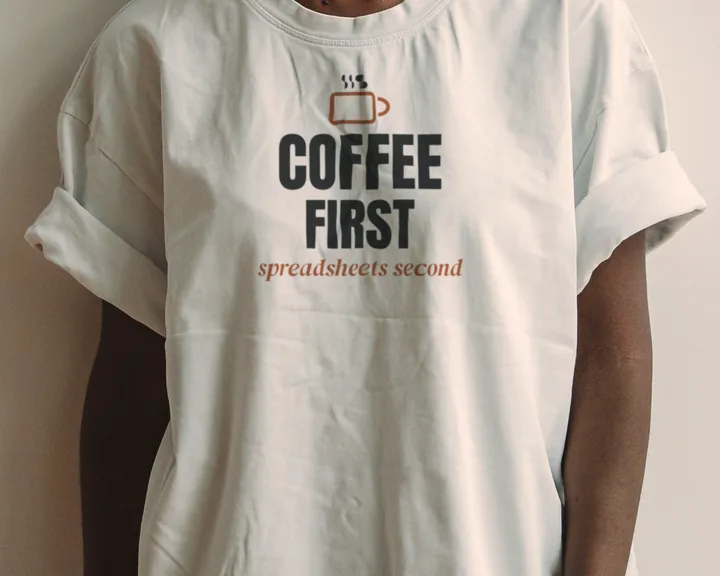 Woman wearing a white "Coffee First, Spreadsheets Second" tee in a bright studio