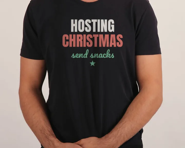 Man wearing a black "Hosting Christmas, Send Snacks" tee in a studio (light-ink print for dark shirts)