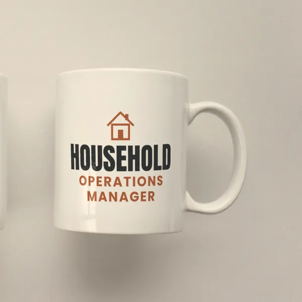 White 11 oz ceramic mug printed with "Household Operations Manager", side view