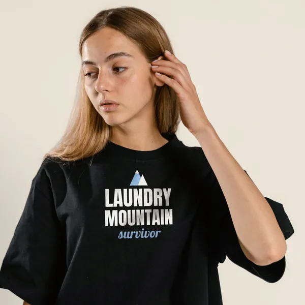 Model wearing a black "Laundry Mountain Survivor" tee with the light-ink version of the design