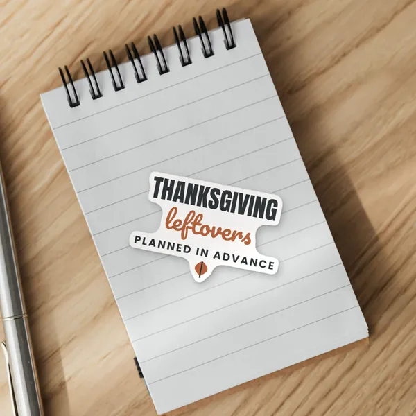 Die-cut "Thanksgiving Leftovers Planned in Advance" vinyl sticker on a spiral notepad