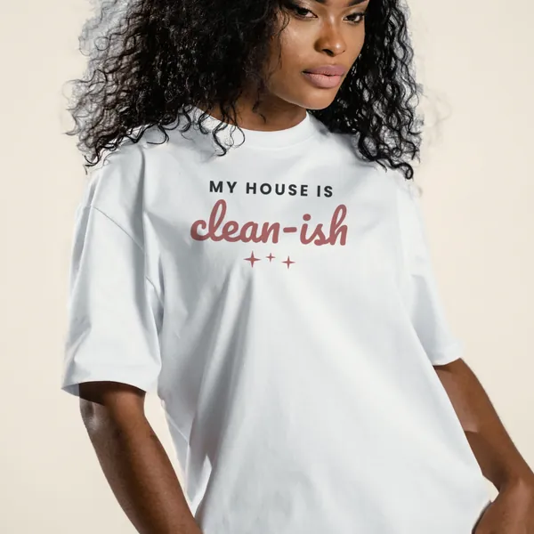 Model wearing a white "My House Is Clean-ish" graphic tee, front view
