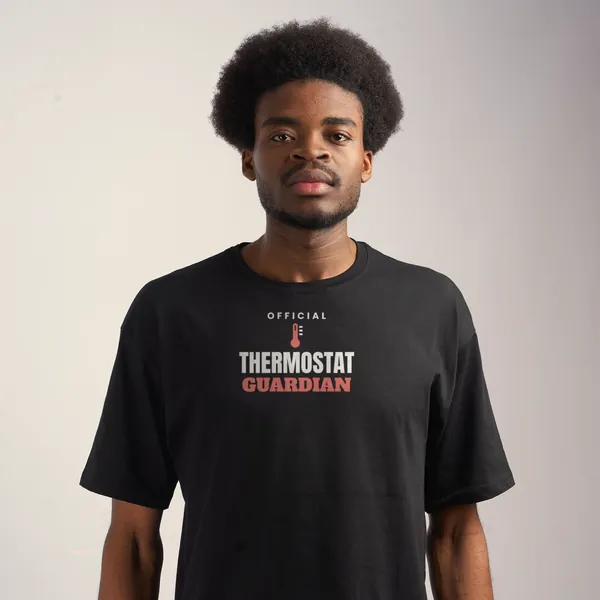 Man wearing a black "Official Thermostat Guardian" tee in a studio (light-ink print for dark shirts)