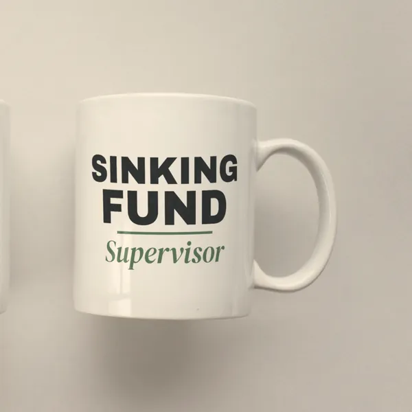 White 11 oz ceramic mug printed with "Sinking Fund Supervisor", side view