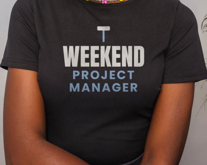 Woman wearing a black "Weekend Project Manager" tee in a studio (light-ink print for dark shirts)