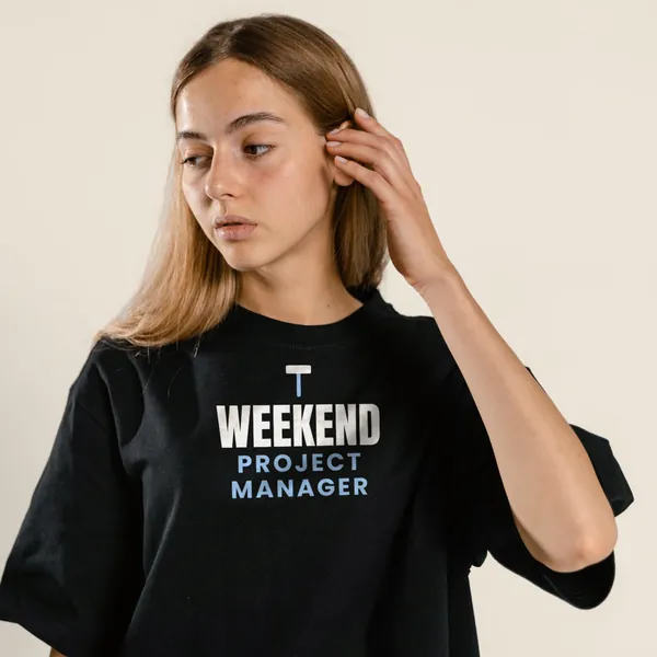 Model wearing a black "Weekend Project Manager" tee with the light-ink version of the design